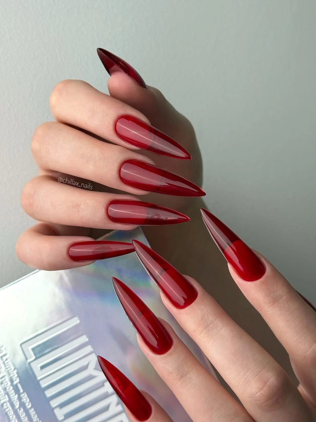 sheer red stiletto nails with glassy borders