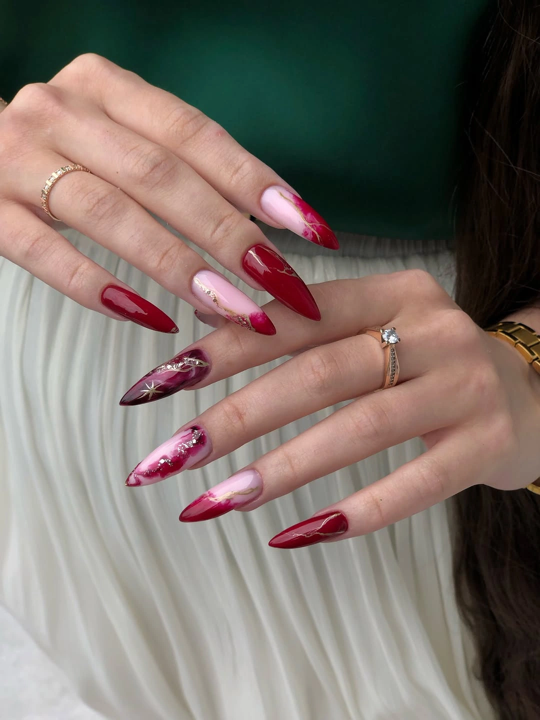 burgundy almond nails with pink marble accents