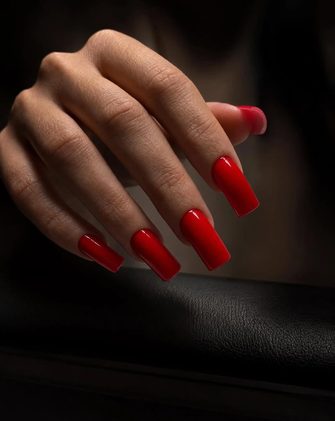 moody red coffin square nails in low light