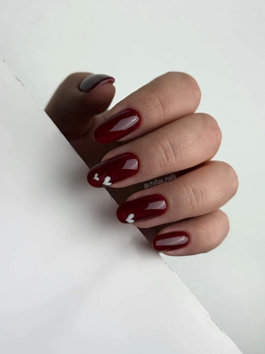 deep red almond nails with white hearts