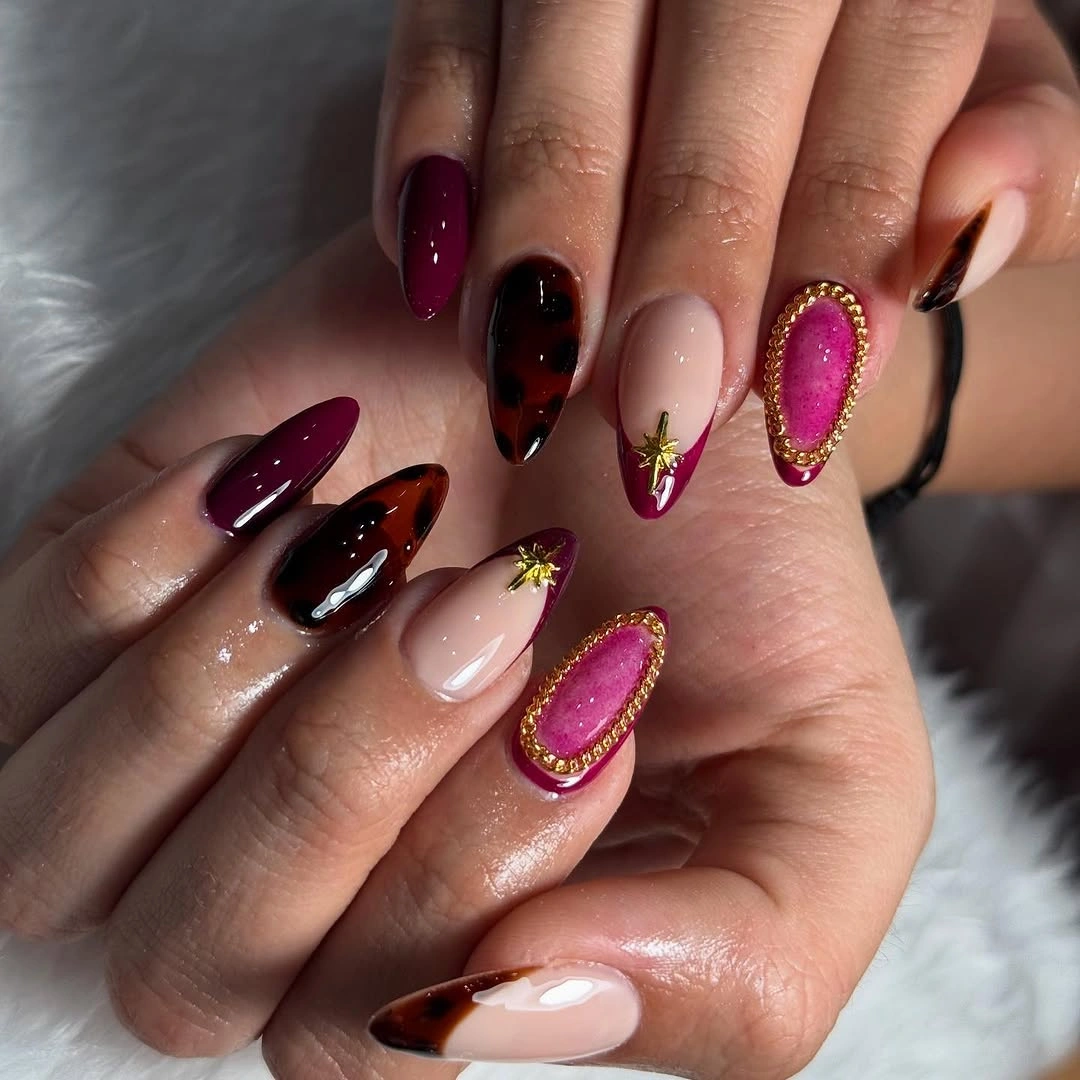 Short almond nails with blush plum berry and gold framed accents
