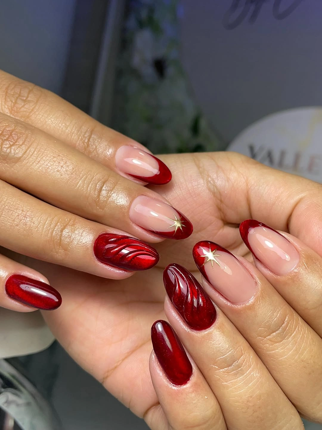 Nude short almond nails with curved red French tips