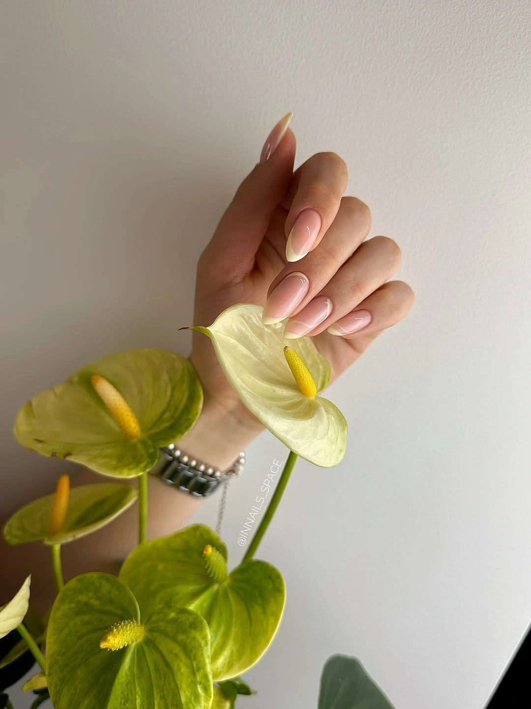 Short blush almond nails with white tips and silver leaf detail