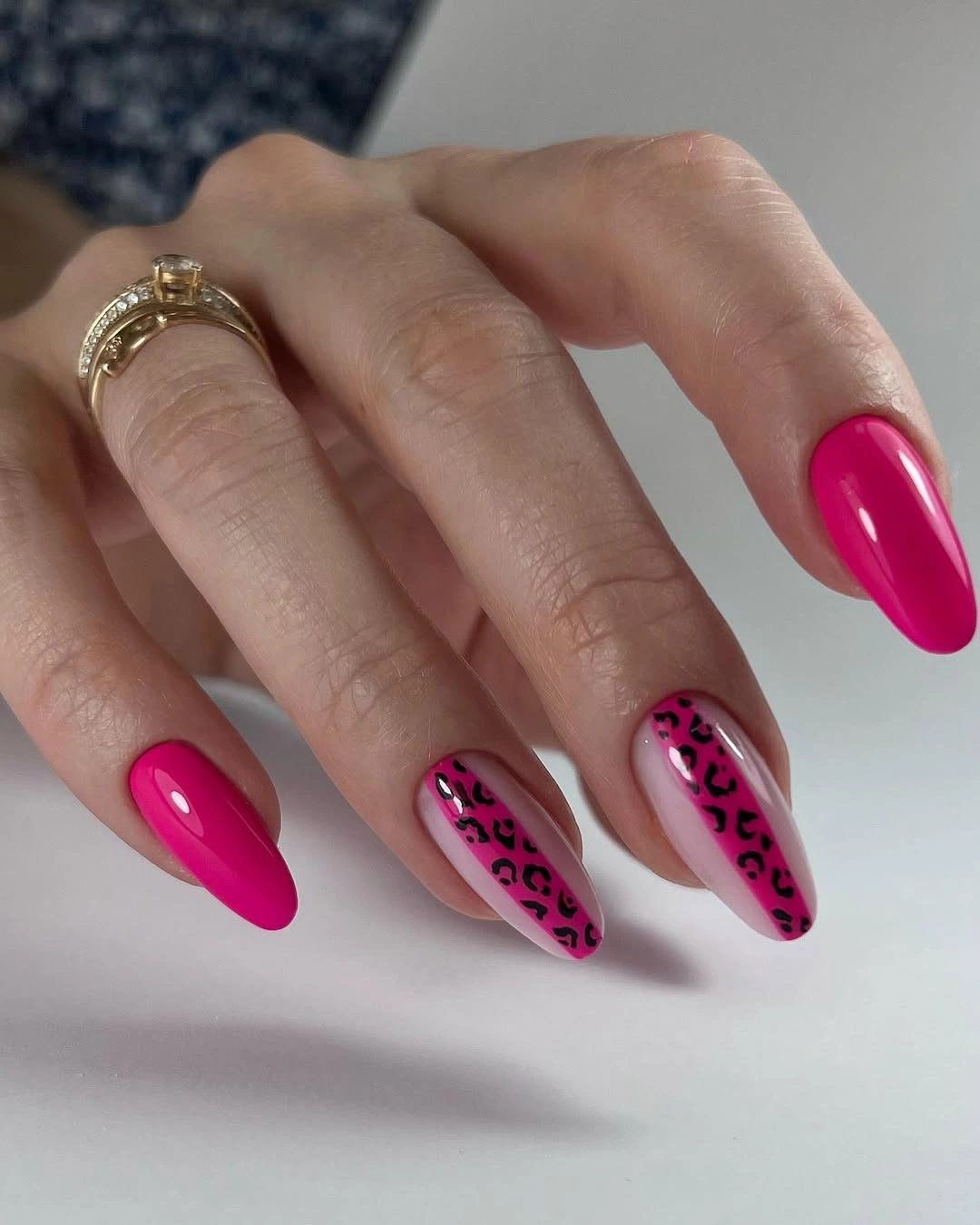 Bright hot pink almond nails with black outlined leopard panels
