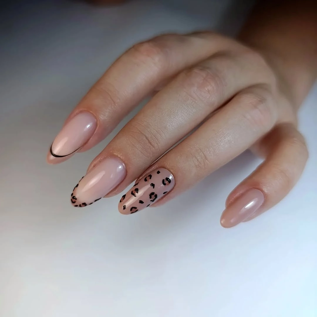 Short almond nails with black French tips and spotted accents