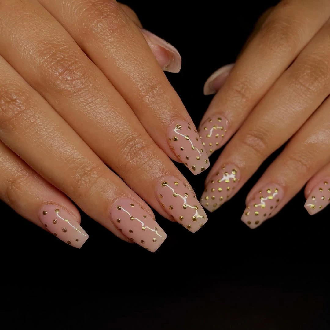 Long tapered square nude nails with tiny warm flecks and stars