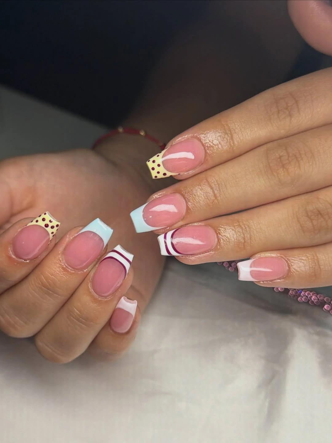 Short rounded square pink nails with checks curves and tiny color accents