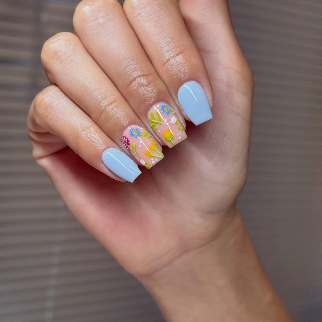 Short square powder blue nails with colorful patterned accents