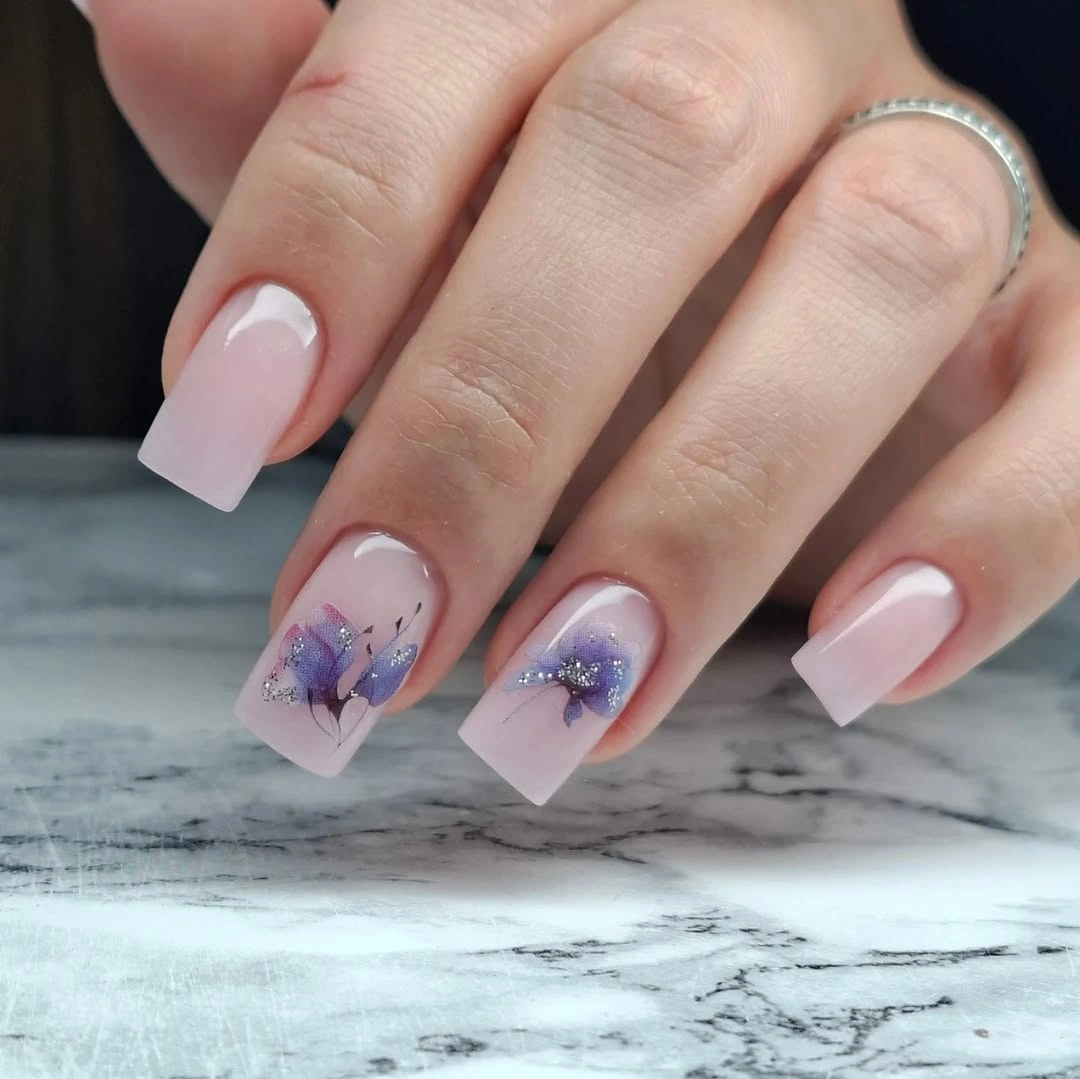Medium square blush nails with purple blue floral accents
