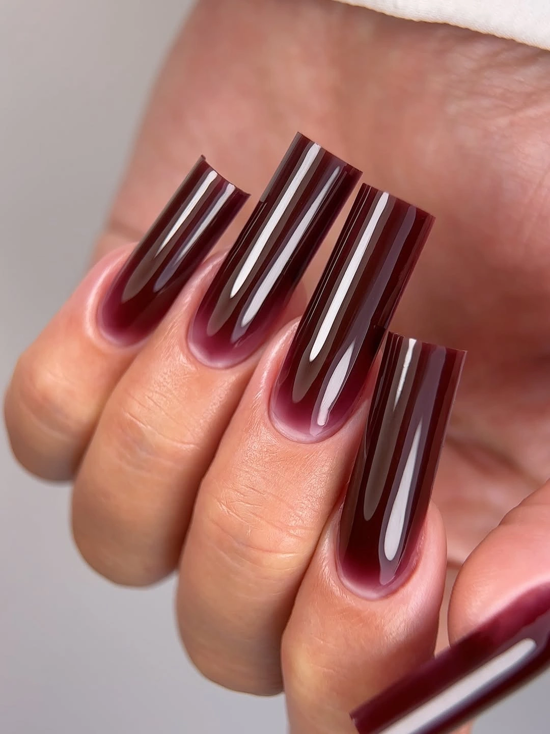 Long square burgundy nails with narrow white stripes