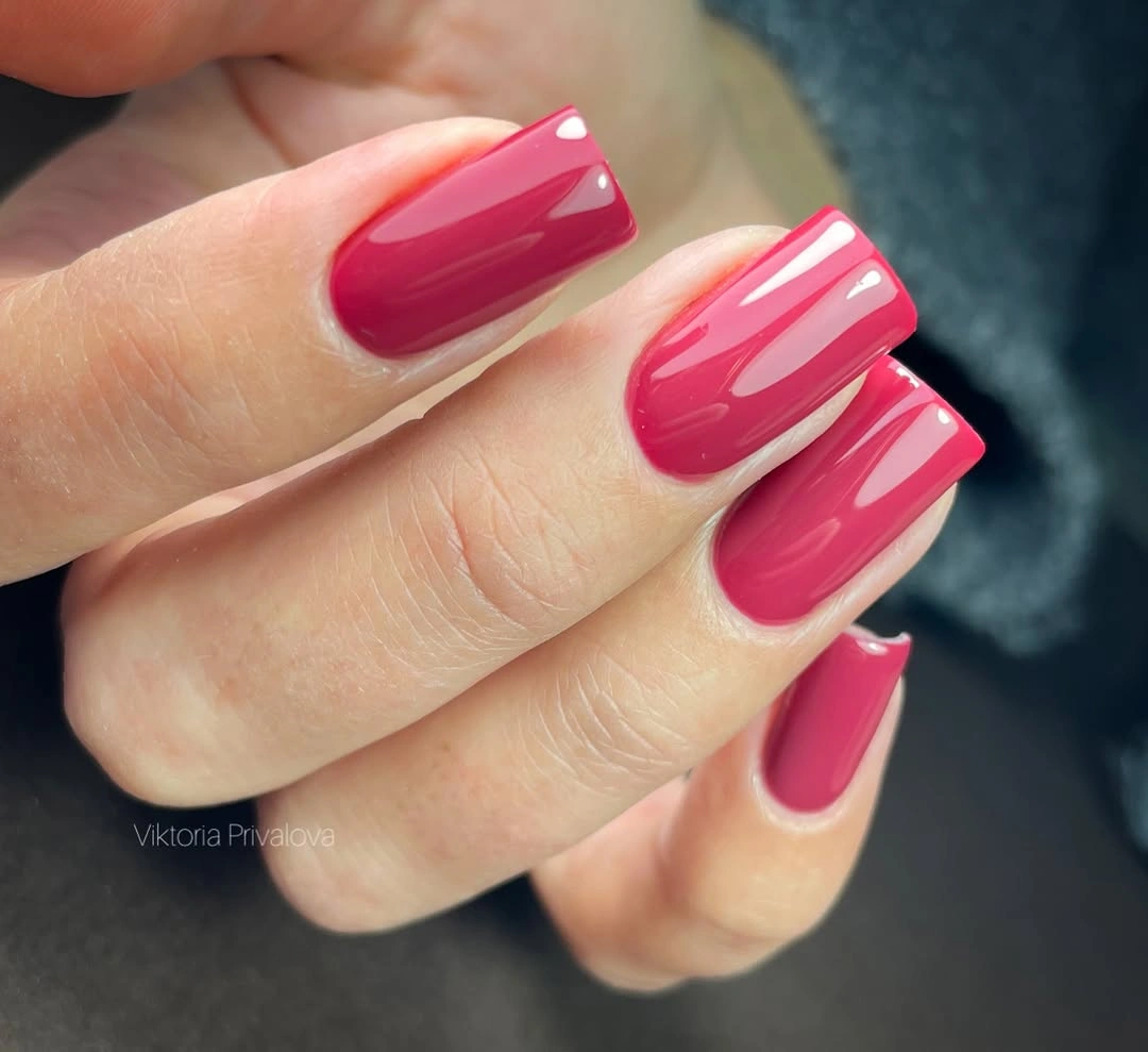 Long square hot pink nails with pale curved lines