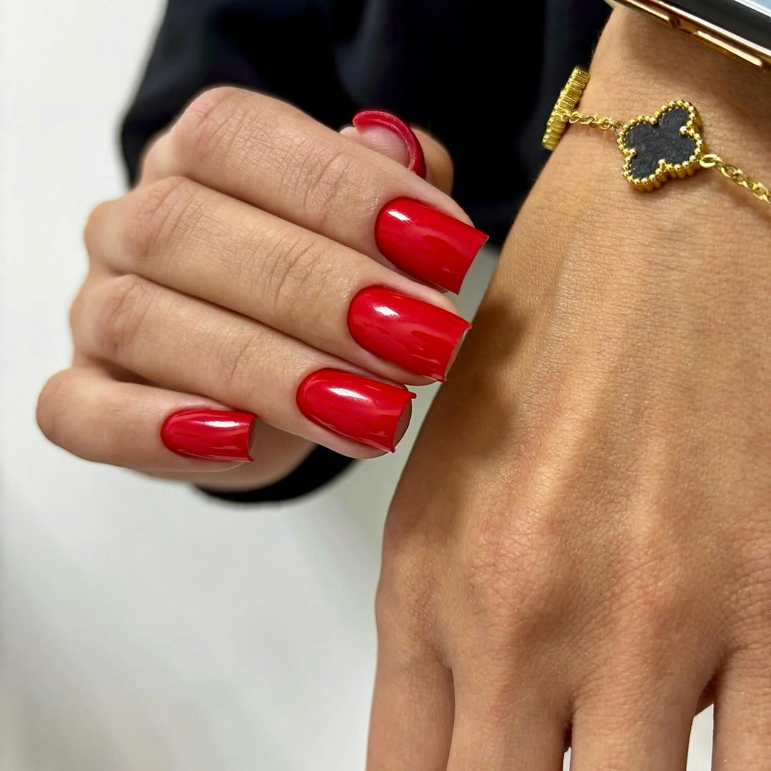 Medium square glossy red nails with gold accessory contrast