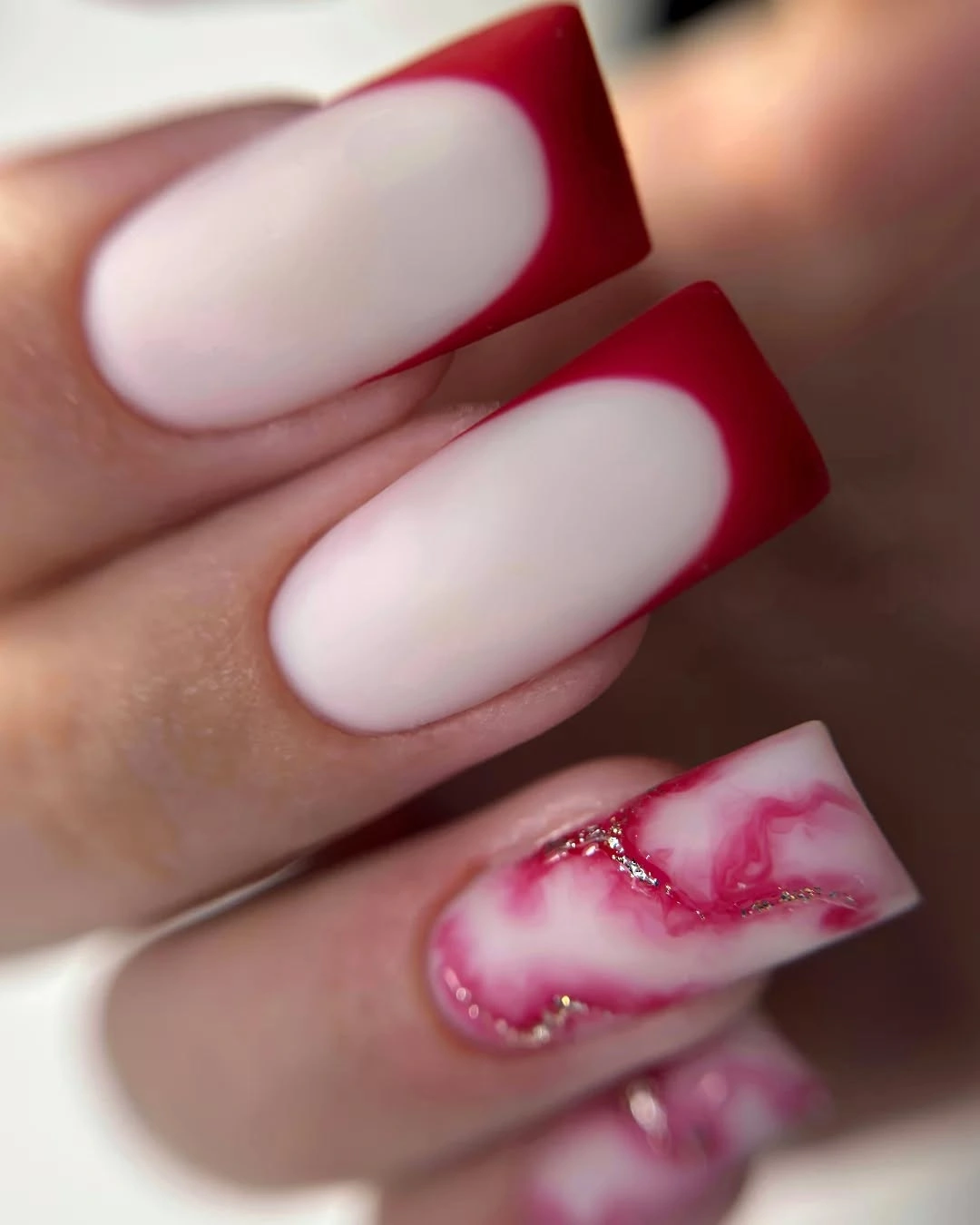Long square pale pink nails with one marbled accent