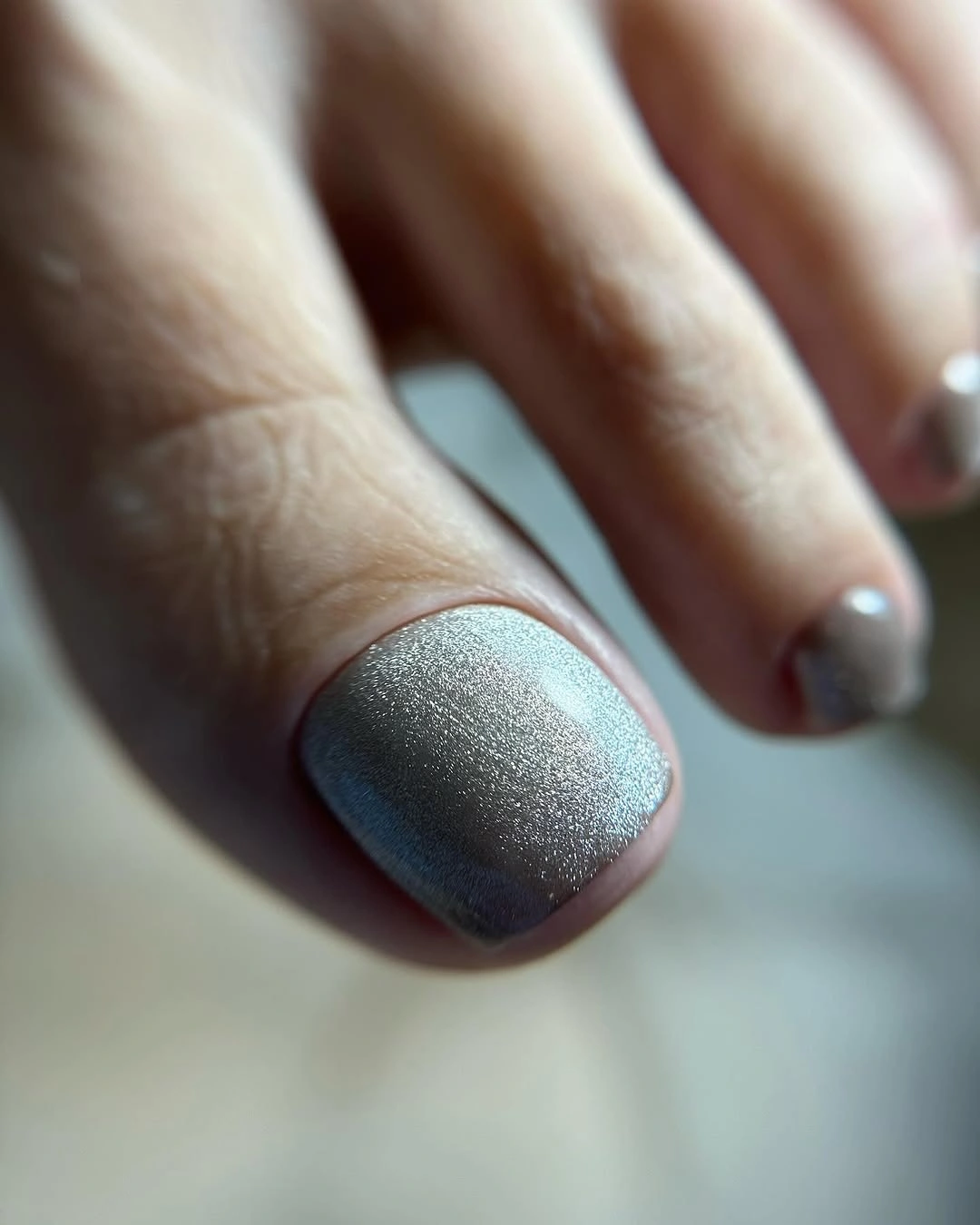 Short square toenails with a smooth metallic silver finish