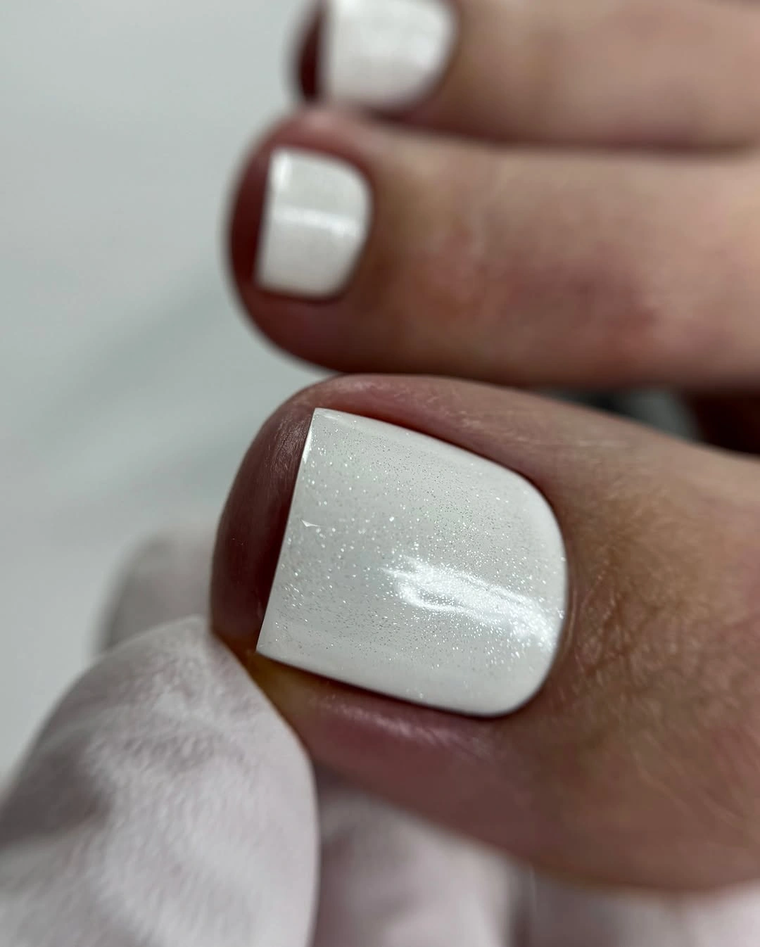 Short white square toenails with a subtle pearly shimmer