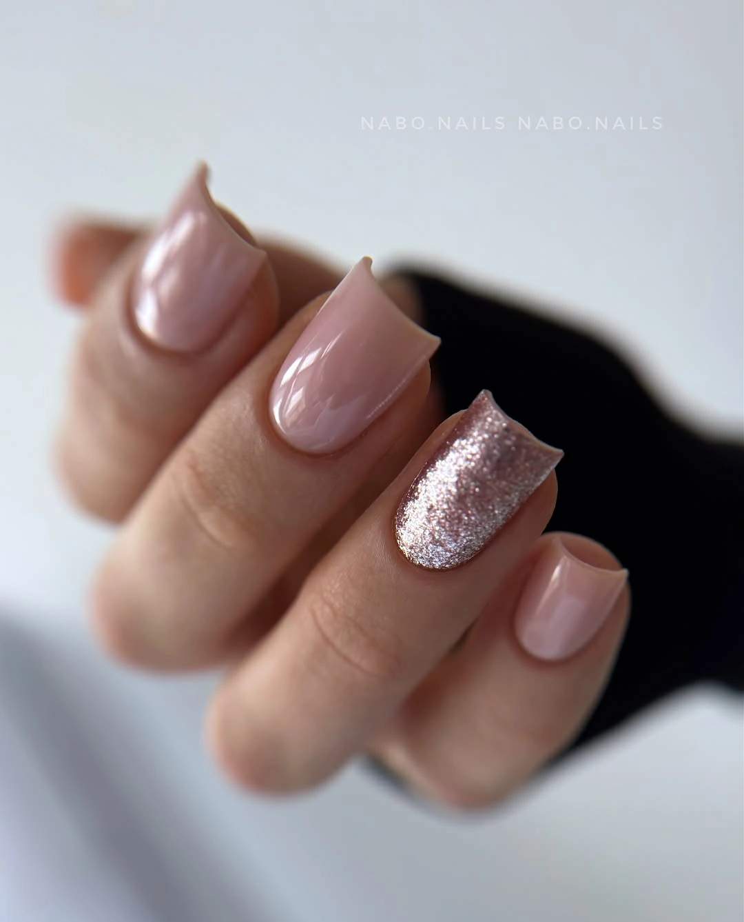 Short pale pink nails with a single silver glitter accent