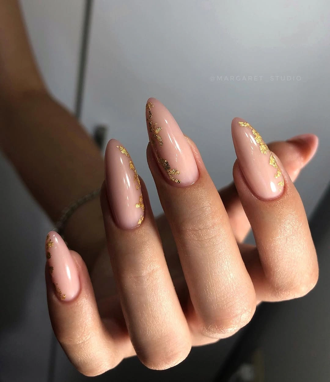 Nude almond nails with irregular gold foil
