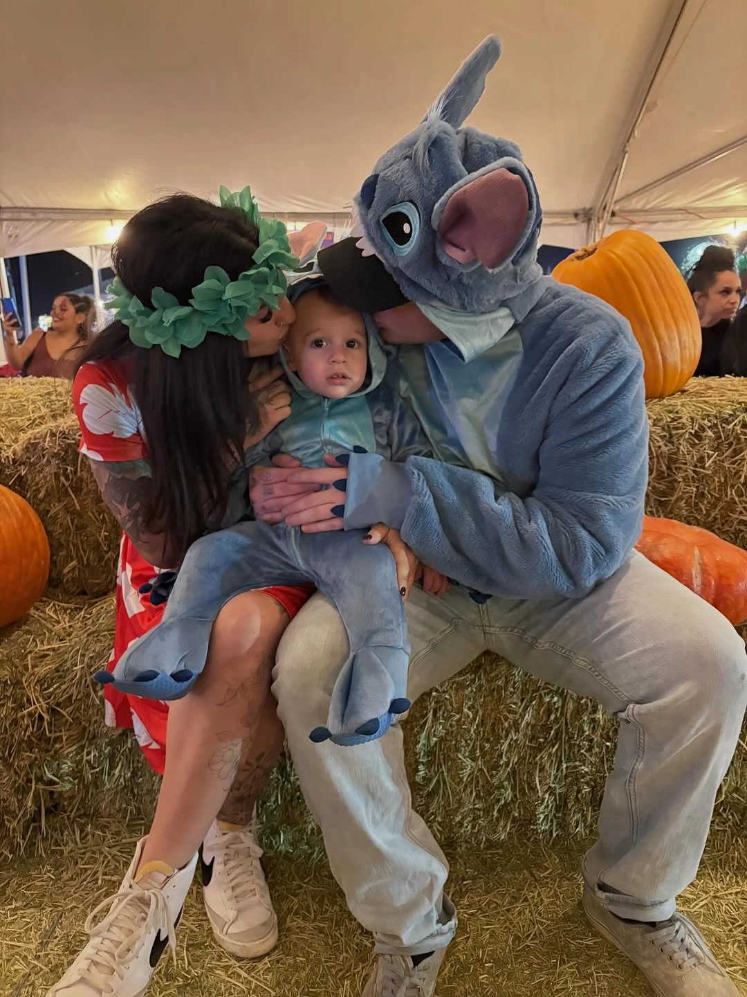 Blue creature family costume with red dress and pumpkin display