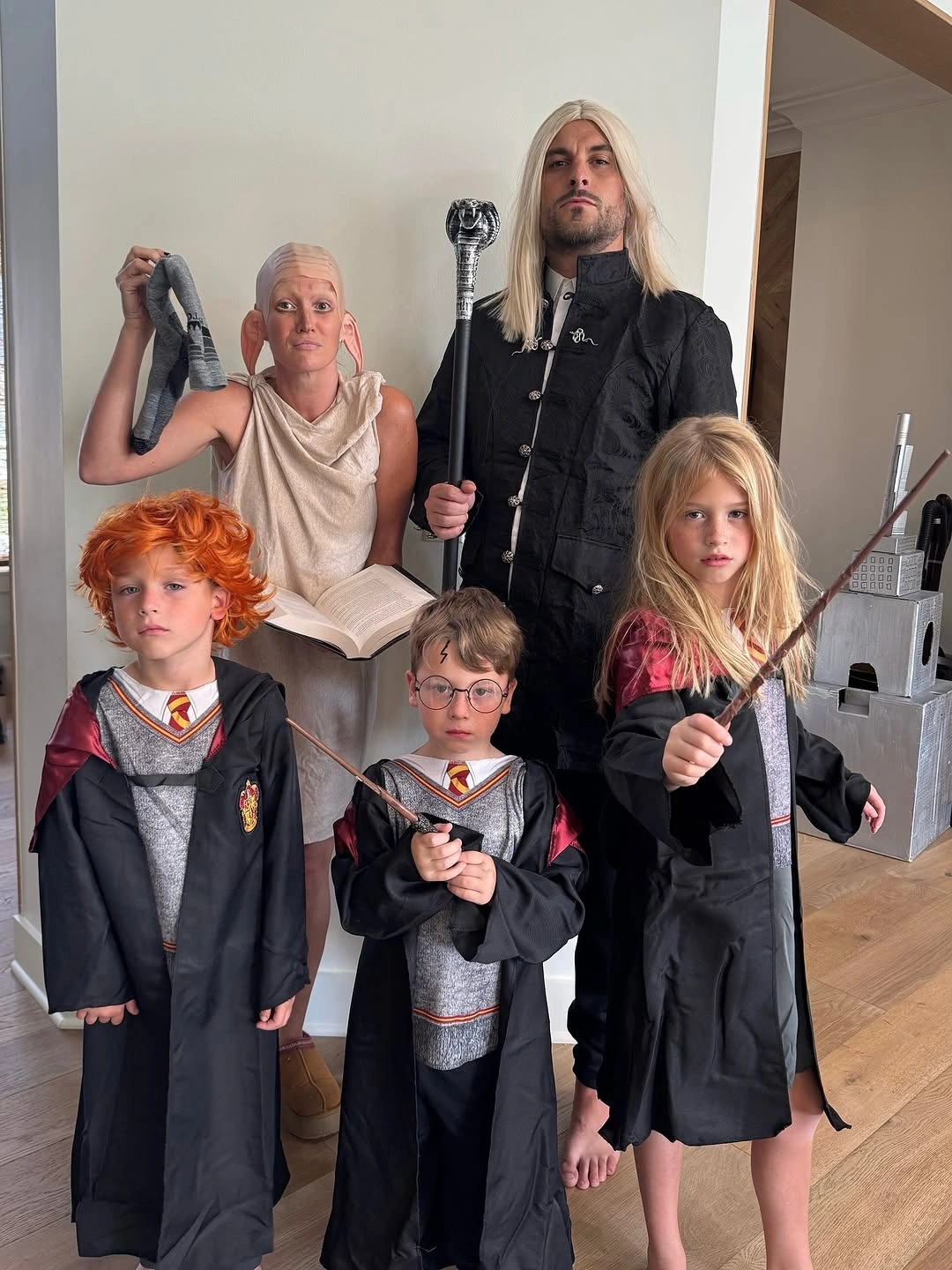Family in dark school uniform inspired costumes with striped scarf