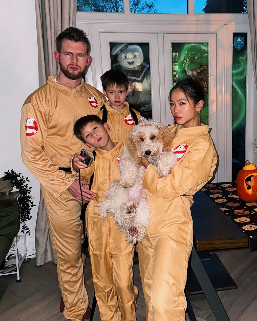 Family in tan jumpsuits with small ghost details and dog