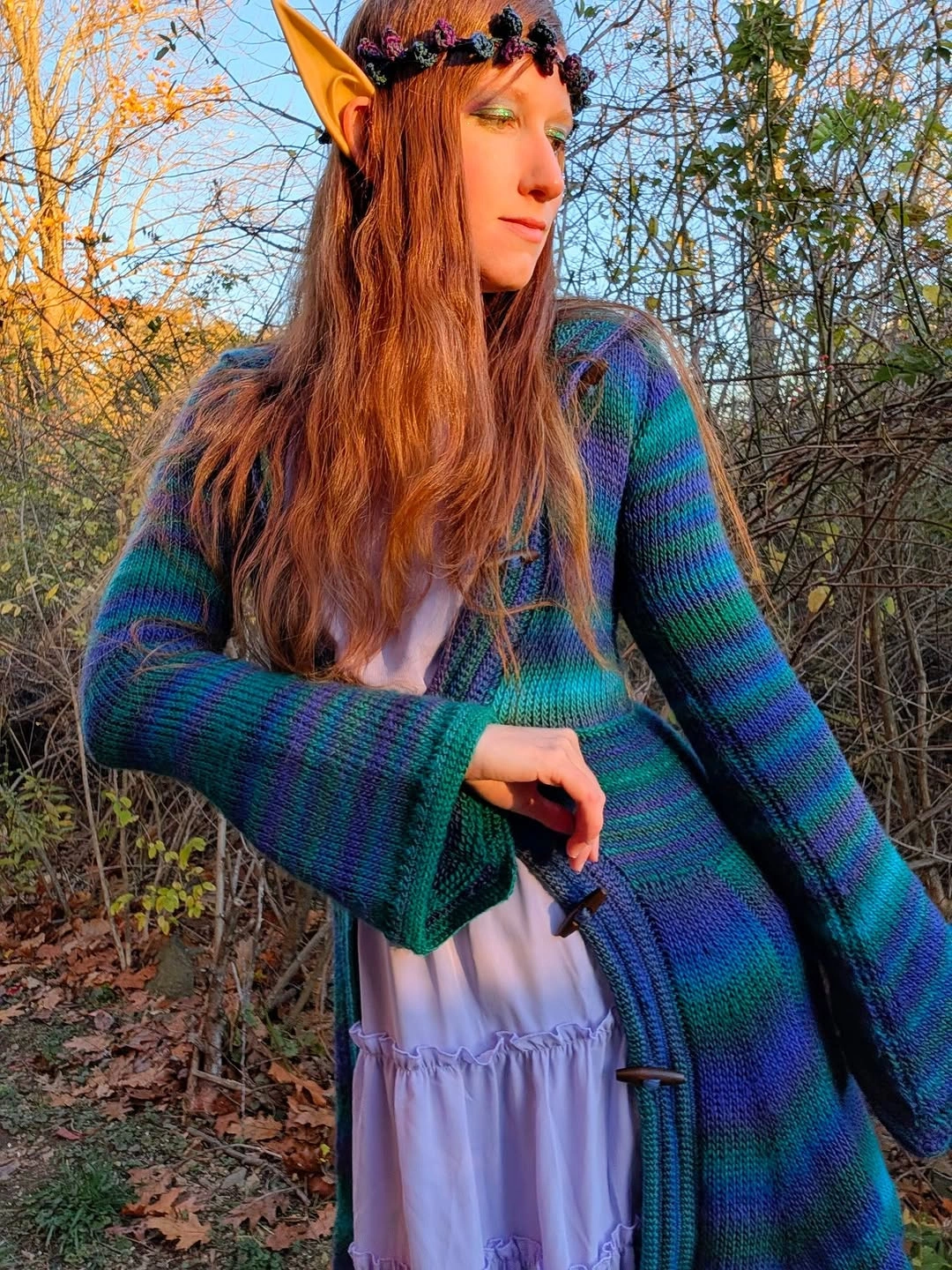 Girl with pointed ear props blue green knit layer and pale skirt