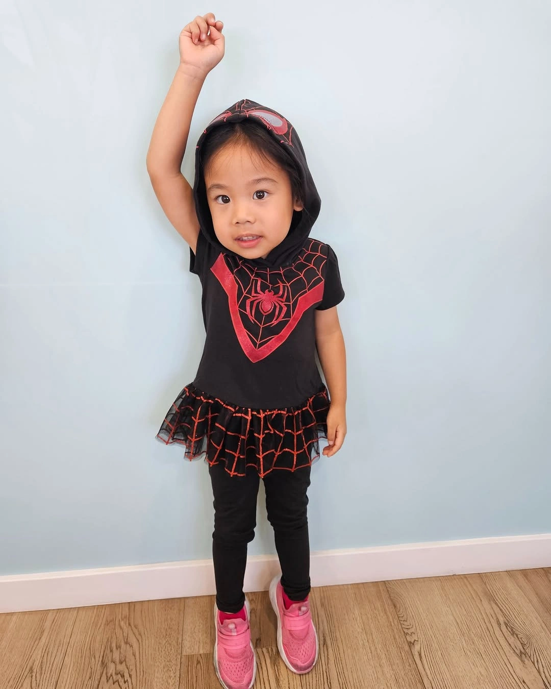 Girl in black red web graphic top tulle skirt leggings and pink shoes