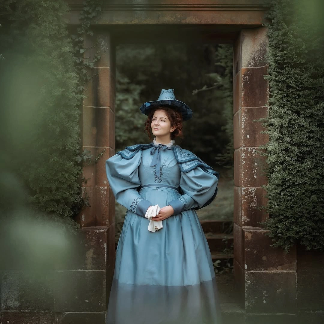 Girl in muted blue witch dress white collar and pointed hat