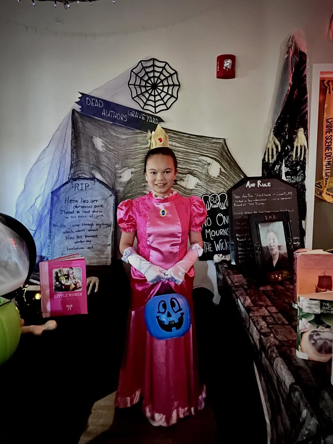 Girl in bright pink princess dress holding blue pumpkin treat bag