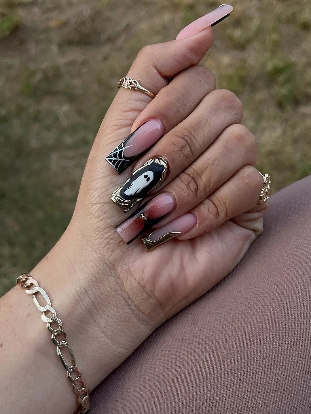 Nude pink Halloween nails with black and white ghosts, spiderweb details, and dark tips
