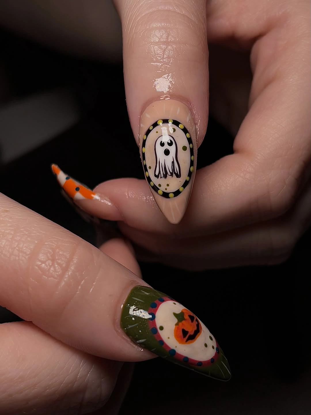 Long green black and purple almond Halloween nails with pumpkin and ghost motifs
