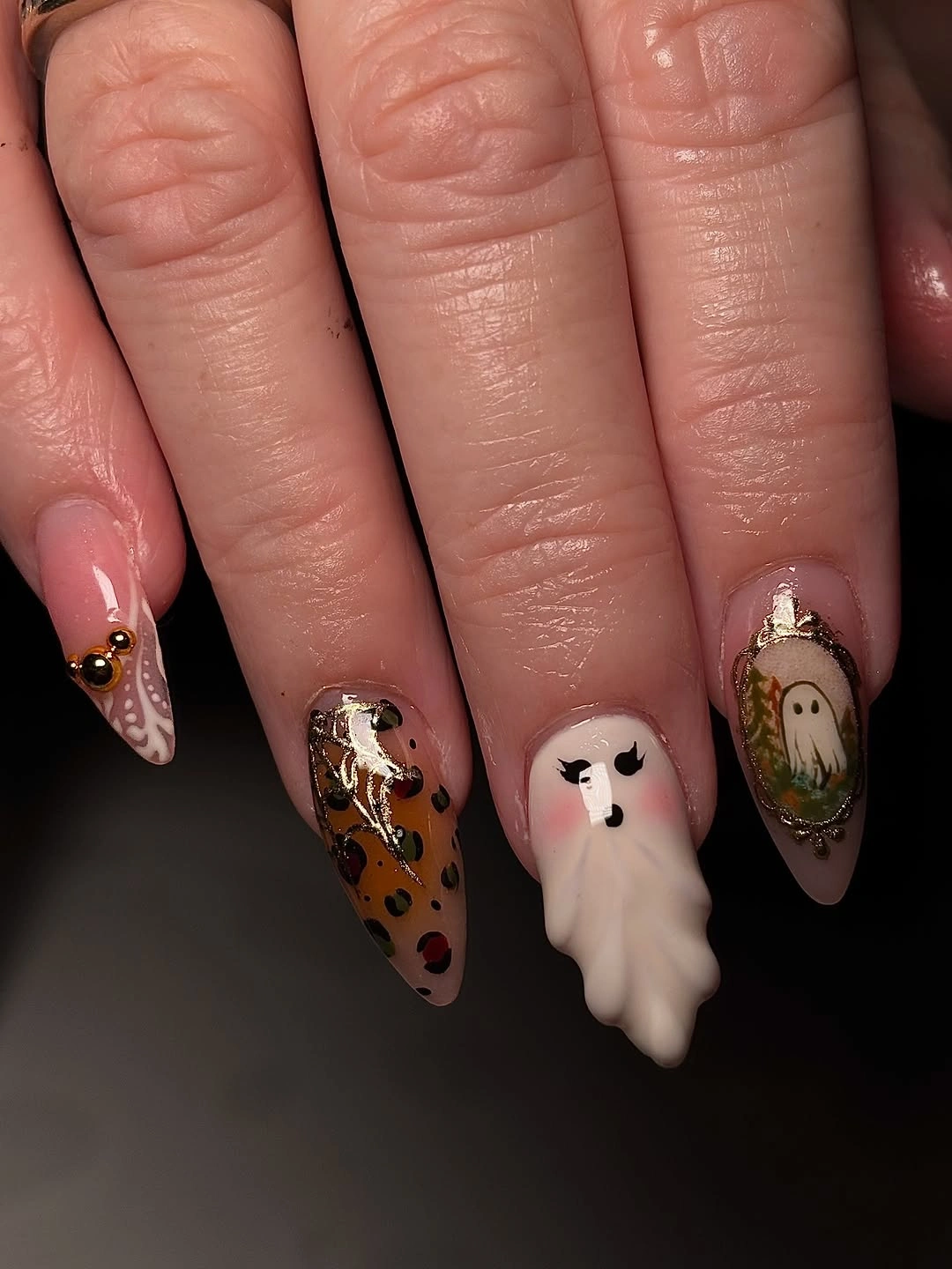 Nude pink Halloween nails with one white dimensional-looking ghost and black orange accent art