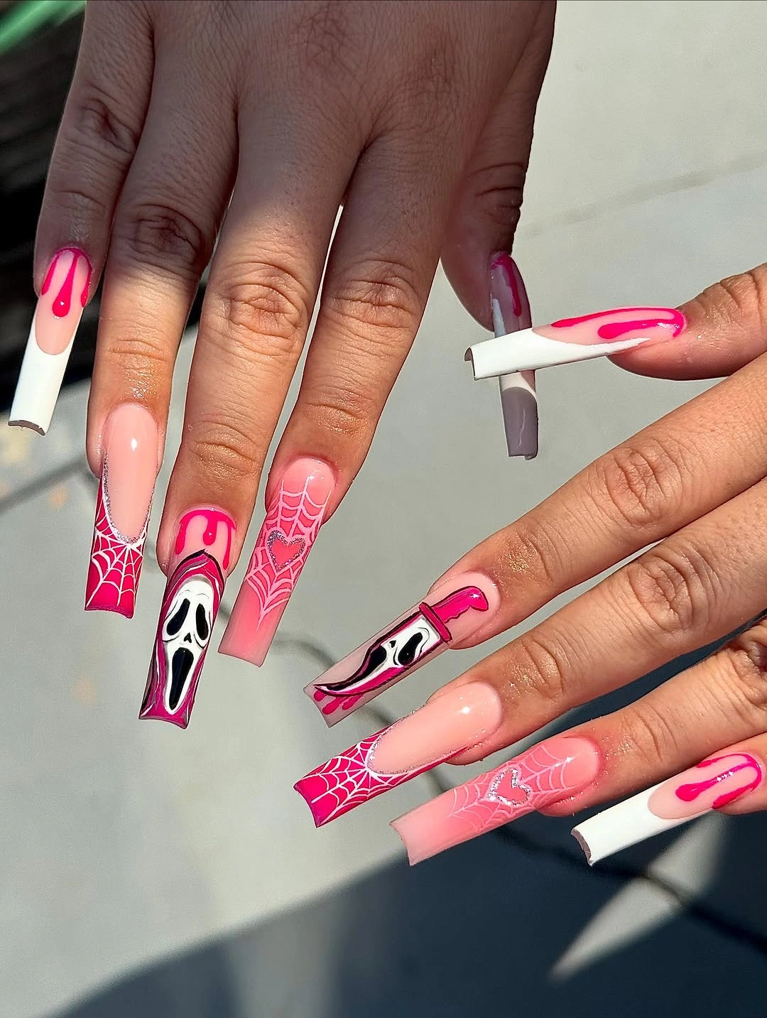 Very long hot pink white and black Halloween nails with spiderweb and ghost graphics