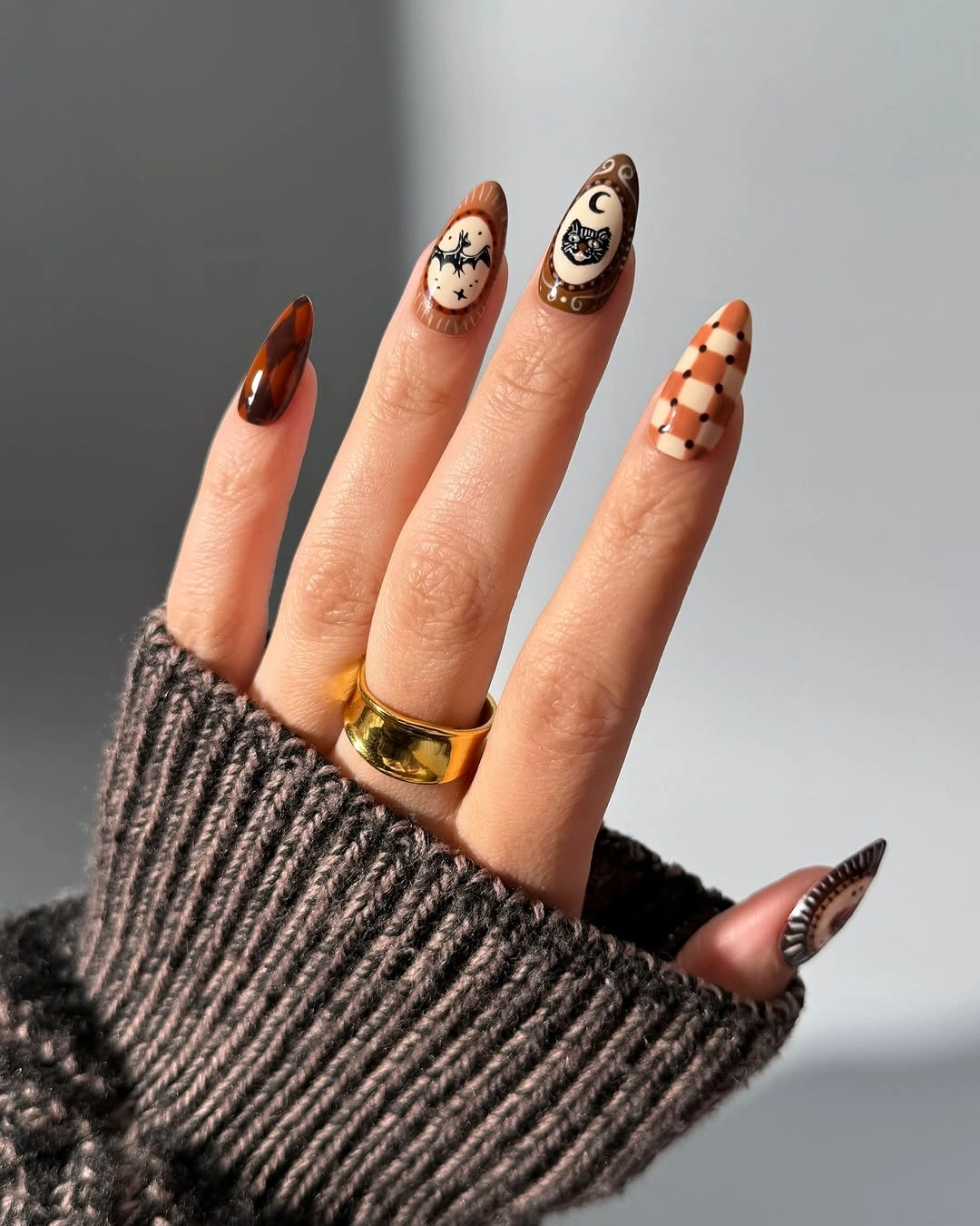 Long nude white brown and orange almond nails with checker, ghost, and pumpkin details