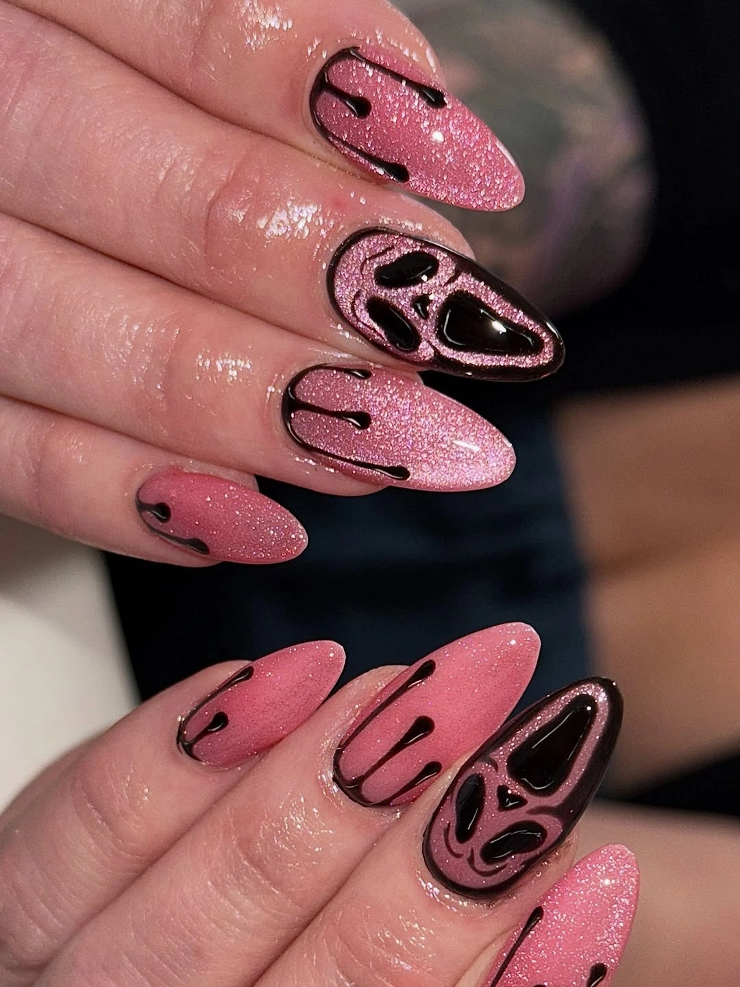 Long pink glitter almond Halloween nails with black dripping and cat-like graphics