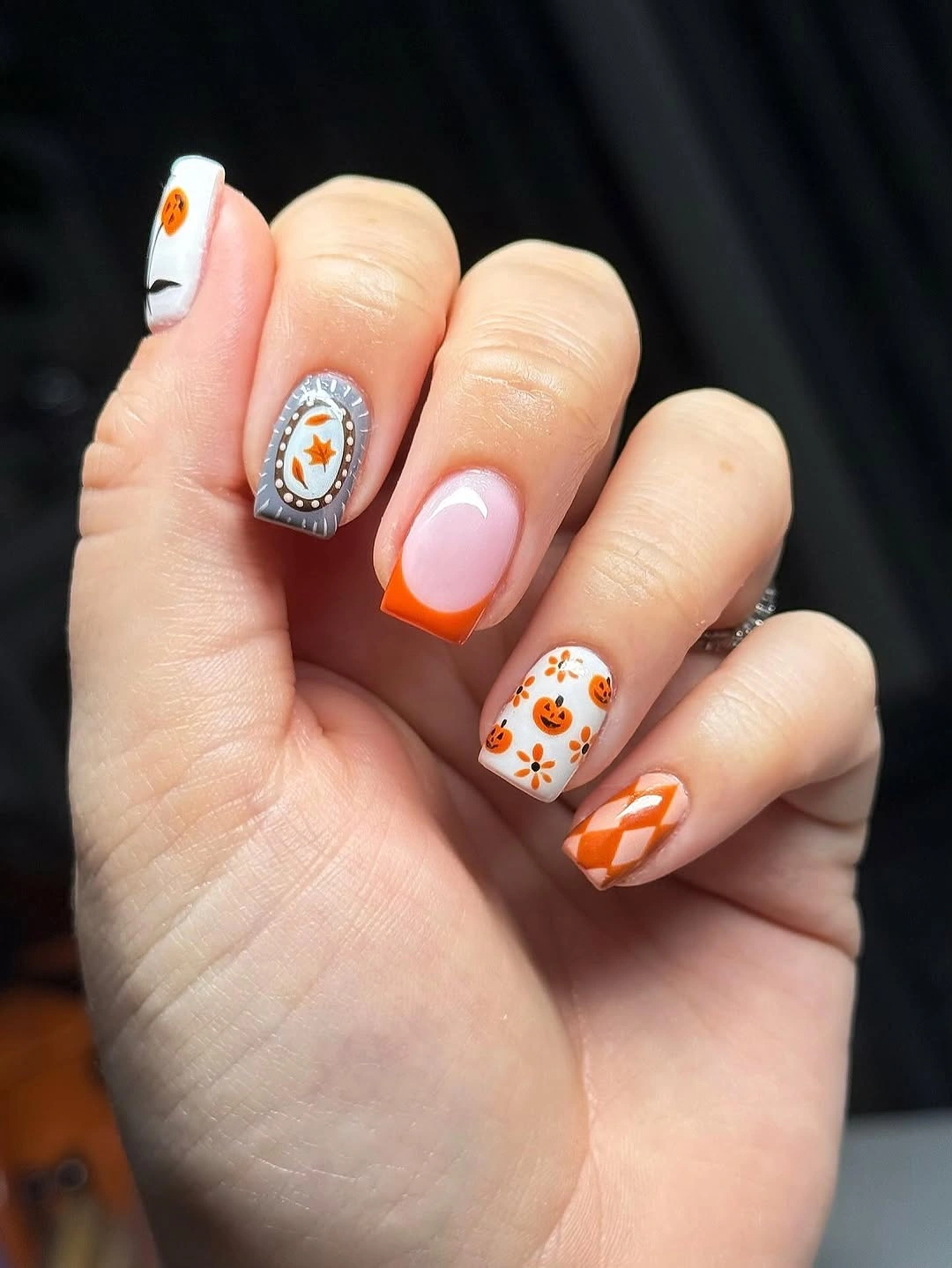 White orange nails with candy stripes ghost pumpkins and black dots