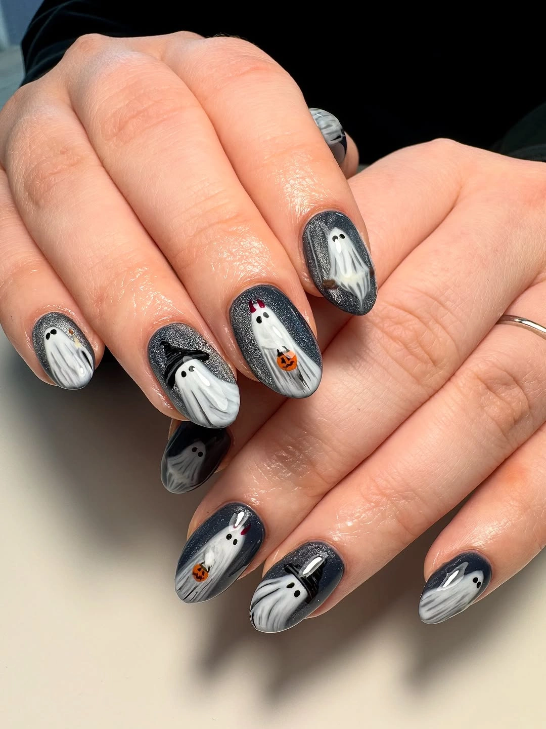 Gray and black nails with repeated white ghost designs