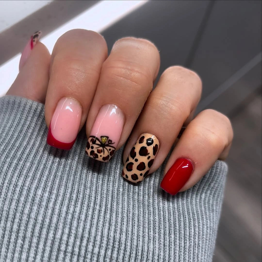 Short pink red French nails with leopard print accents