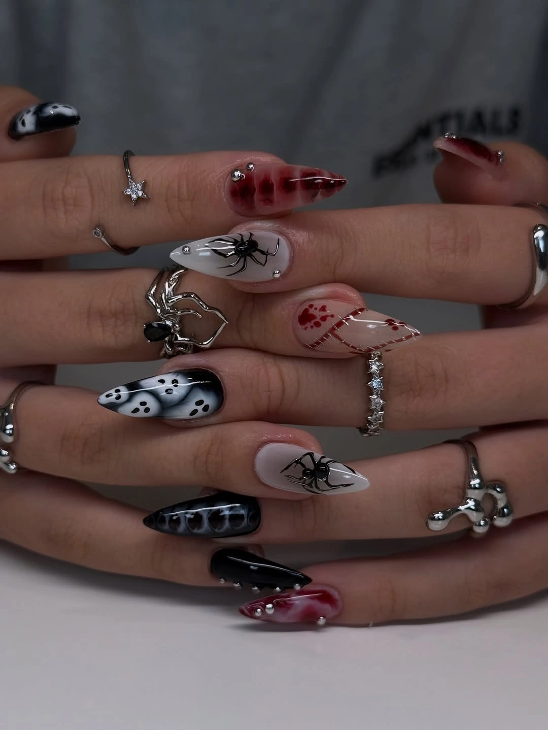 Black red and white Halloween nails with spiders, ghosts, and graphic spooky line art