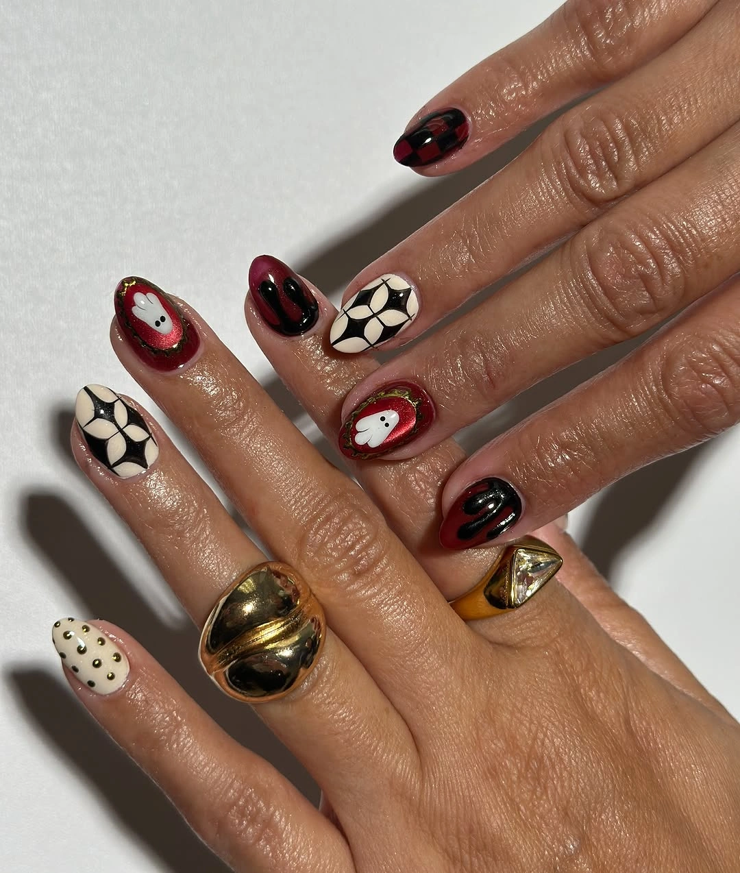 Burgundy white and black Halloween nails with floral, checker, and ghost details