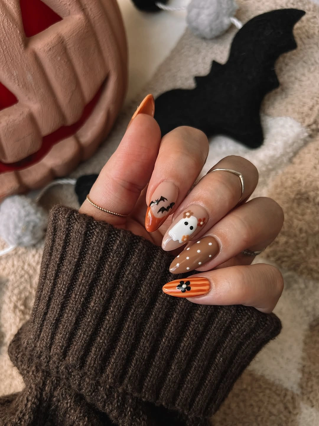Medium pumpkin orange and brown Halloween nails with a friendly ghost and black linework