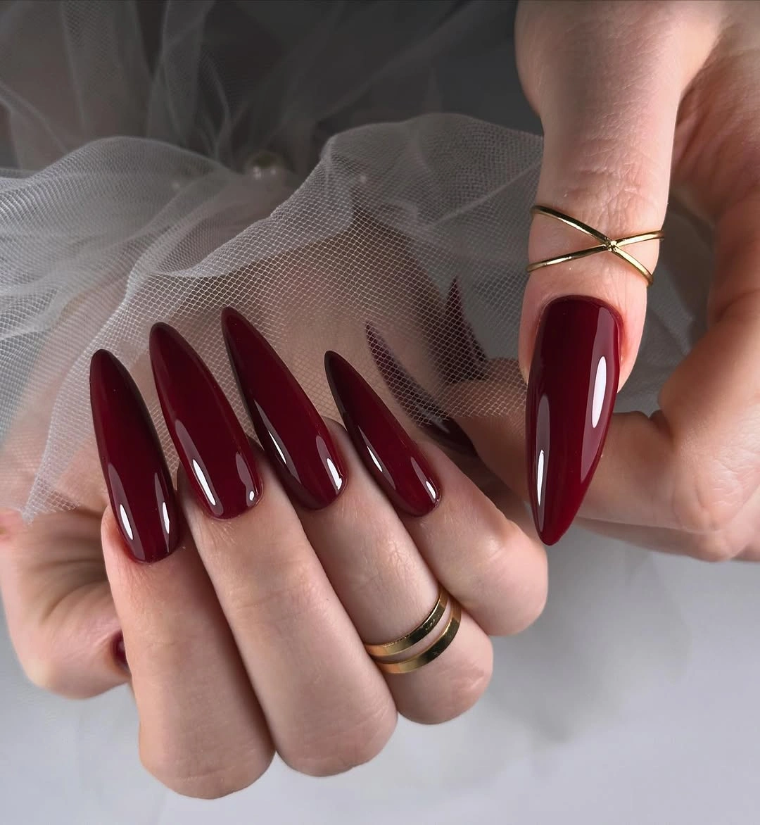 Long pointed maroon nails with glossy tapered silhouette