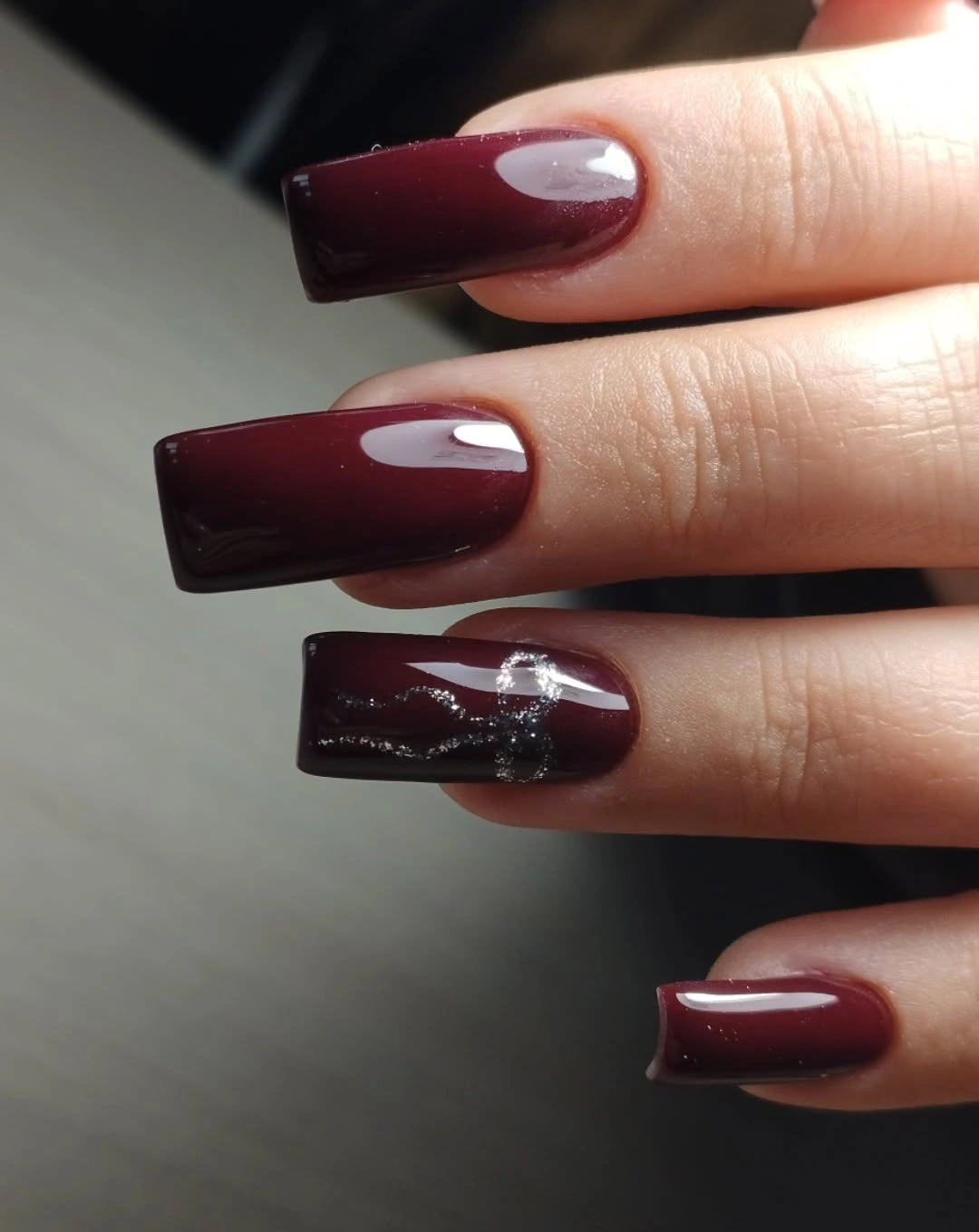 Long burgundy square nails with silver abstract accent strokes