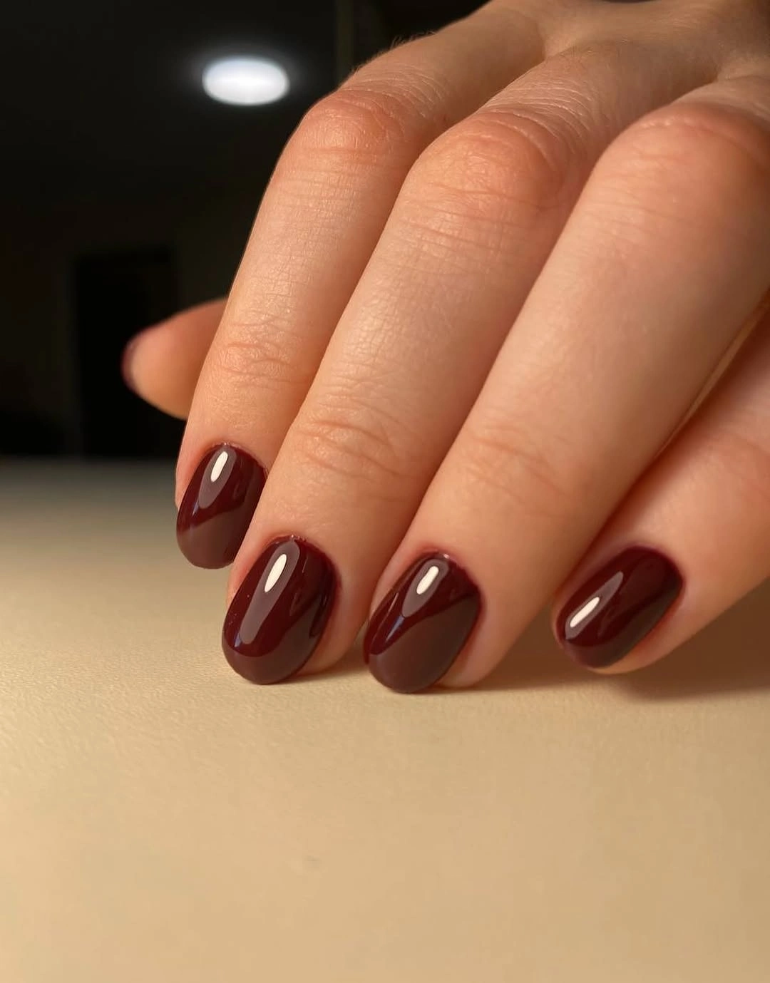 Medium almond nails in warm brown leaning maroon