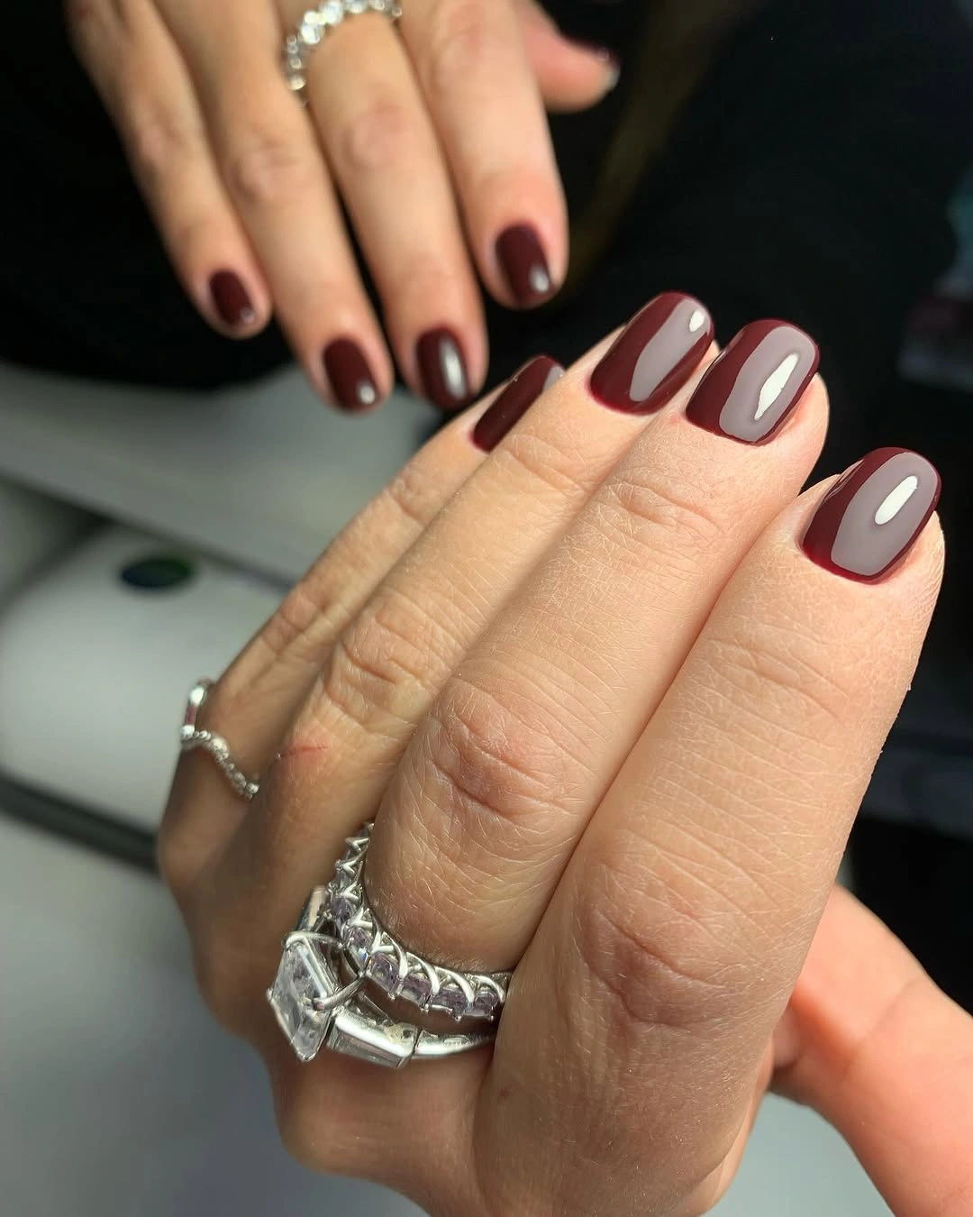 Short maroon and pale blocked nails with dark outlines