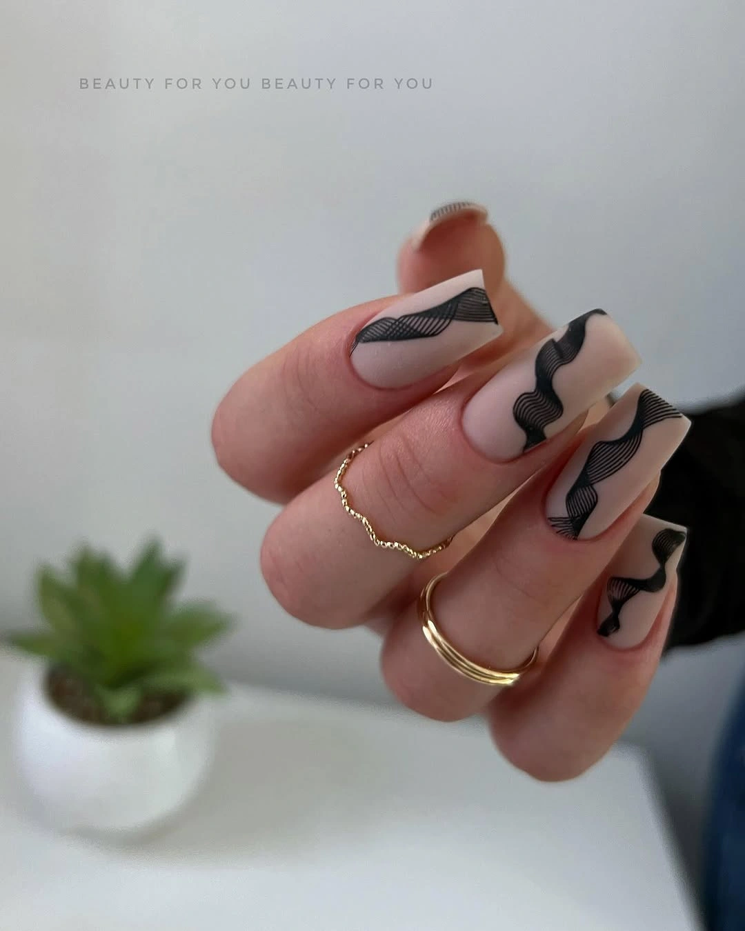 Nude square nails with flowing black wave outline details