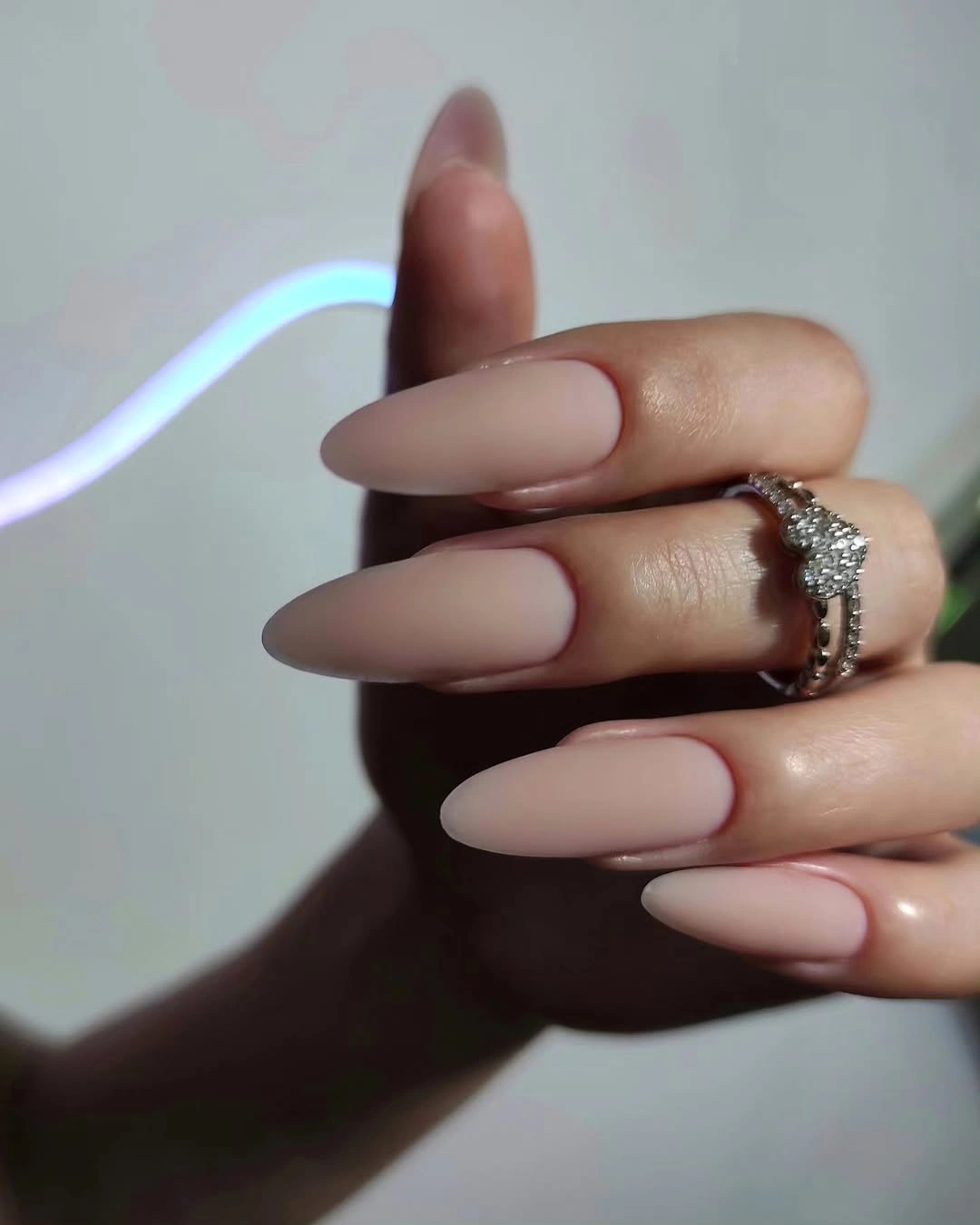 Long nude almond nails with thin muted burgundy edge details