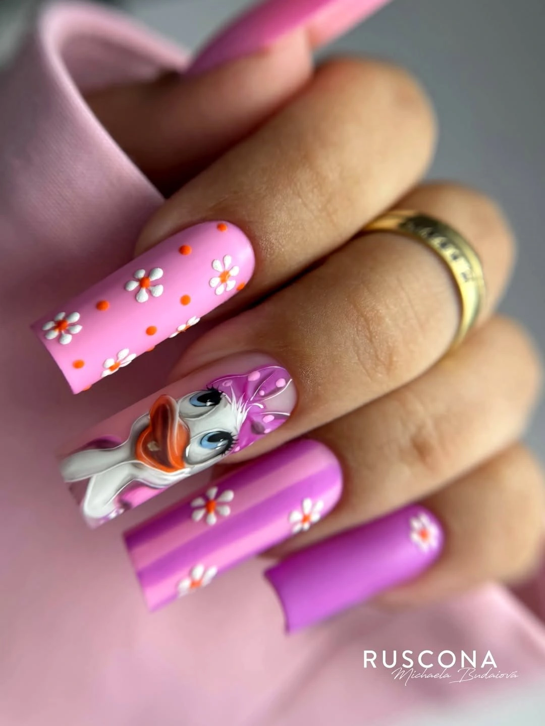 Bright pink square nails with white daisies and character accent