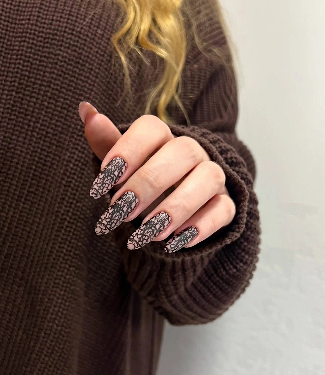 Neutral almond nails with dense black ornamental linework accents