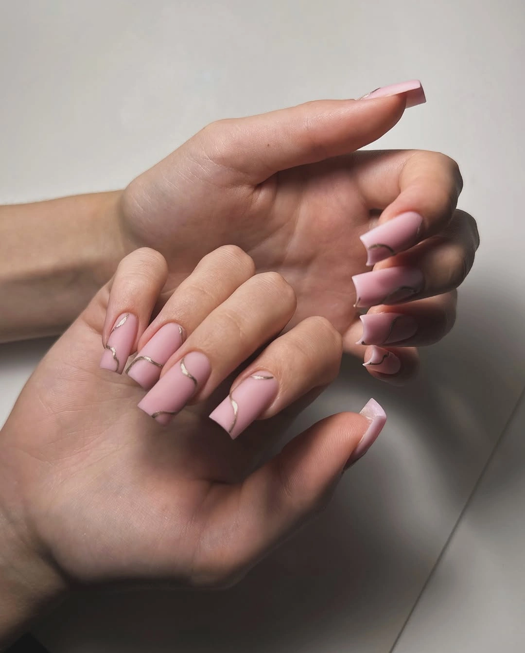 Pale pink long square nails with delicate curved tip lines