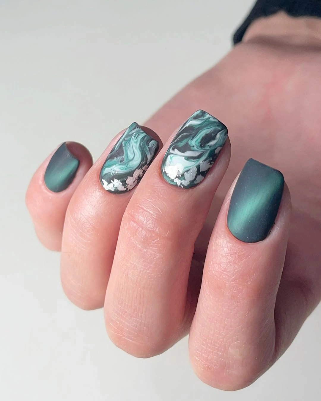 Deep green square nails with pale marbled accent nails